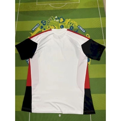 Camisola desportiva branca, preta e vermelha sobre fundo verde com padrão de campo