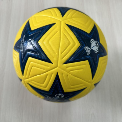 Bola de futebol amarela com estrelas azuis e relevo geométrico