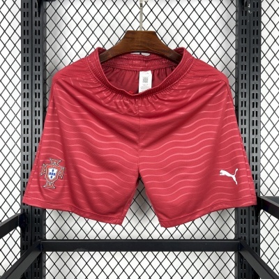 Calções vermelhos com brasão de Portugal e logo Puma pendurados em cabide