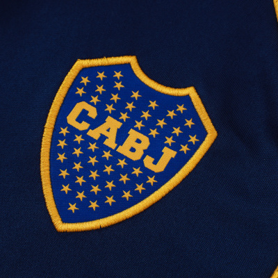Escudo bordado CABJ em tecido azul com tecido amarelo perfurado ao lado