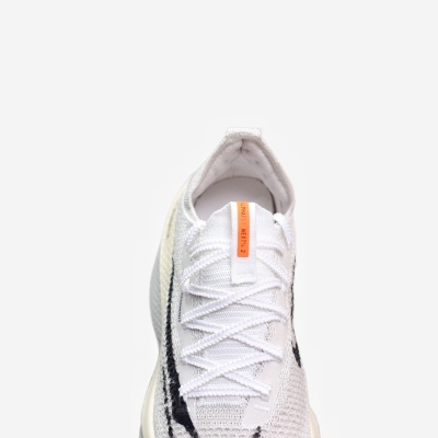 Ténis desportivo branco com detalhes pretos e etiqueta laranja