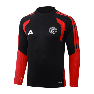 Camisola de treino Manchester United preta e vermelha com mangas compridas e logótipos visíveis.