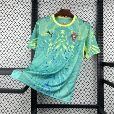 Camisola de futebol verde claro com padrão geométrico e emblema de Portugal pendurada num cabide