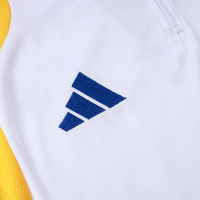 Roupa desportiva branca com detalhes amarelos e símbolo azul bordado