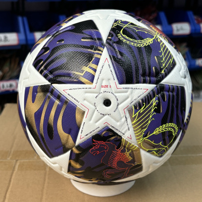 Bola de futebol branca com detalhes em roxo, preto, amarelo e vermelho, texto impresso em vários idiomas
