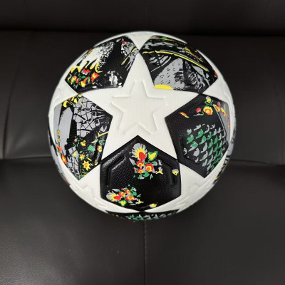 Bola de futebol branca com padrão de estrelas e painéis pretos florais.