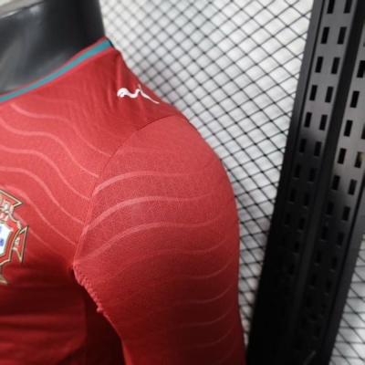 Camisola desportiva vermelha com emblema e padrões ondulados em manequim