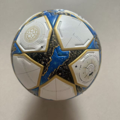 Bola de futebol branca, azul, preta e dourada com texto e padrões detalhados