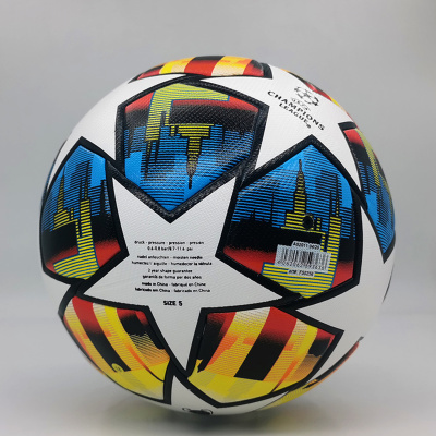 Bola de futebol branca com padrão colorido e texto UEFA CHAMPIONS LEAGUE