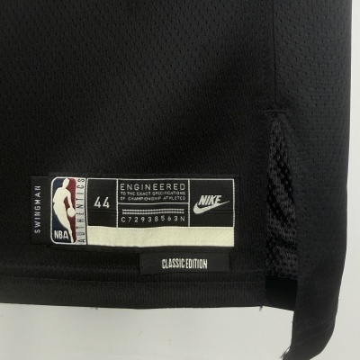 Etiqueta em tecido preto e branco num tecido esportivo preto com logótipos NBA e Nike e textos sobre especificações do produto