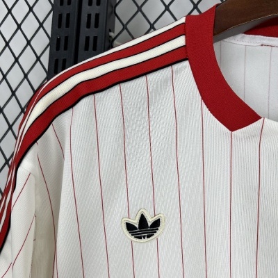 Camiseta branca com riscas vermelhas e símbolo Adidas no peito