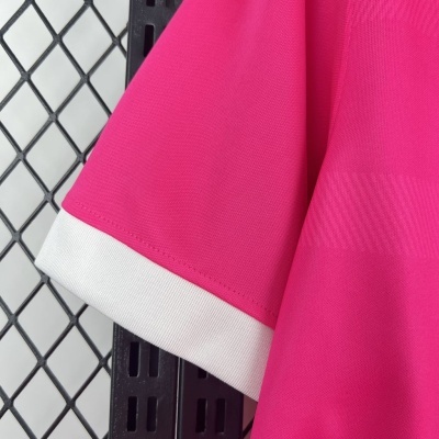 Punho de manga cor-de-rosa com acabamento branco pendurada numa estrutura metálica preta