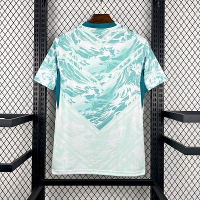 T-shirt desportiva azul e branca pendurada em suporte metálico preto com fundo de rede