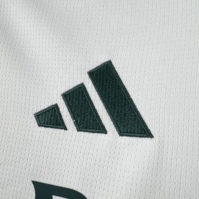 Tecido branco com símbolo preto bordado em forma de três barras verticais inclinadas.