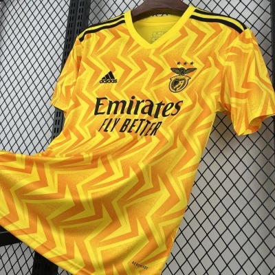 T-shirt de futebol amarela com padrão laranja, logos adidas e Benfica em preto