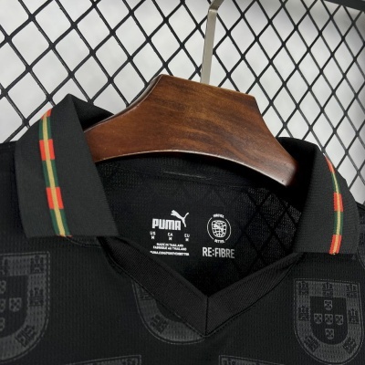 Camisola preta Puma com gola preta e riscas verdes e vermelhas, padrão do escudo de Portugal, pendurada em cabide de madeira