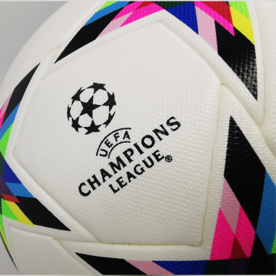 Bola de futebol branca com padrões geométricos coloridos e texto UEFA CHAMPIONS LEAGUE.