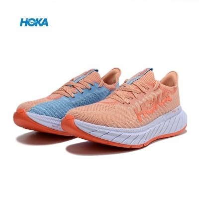 Sapatilhas desportivas HOKA azul e cor de pêssego com sola branca e detalhes em laranja.
