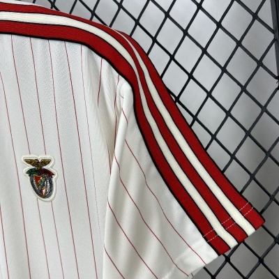 T-shirt branca com riscas vermelhas e emblema bordado colorido numa manga
