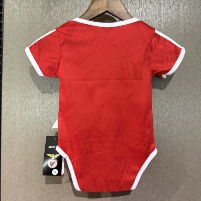 Body vermelho de bebé com bordas brancas pendurado num cabide