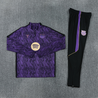 Conjunto de treino roxo e preto com logos do Barcelona e Spotify sobre tapete cinza