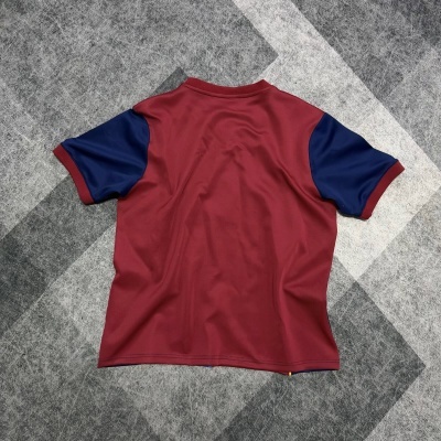 T-shirt de manga curta bicolor borgonha e azul escuro sobre chão com padrão cinza