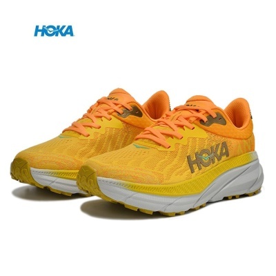 Ténis HOKA amarelos e laranja com sola branca e logótipo cinzento.