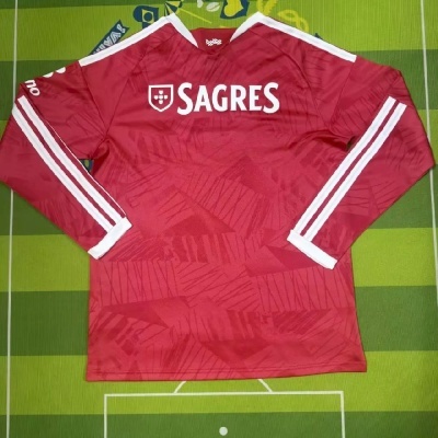 Camisola desportiva vermelha com riscas brancas e logo SAGRES em fundo verde.