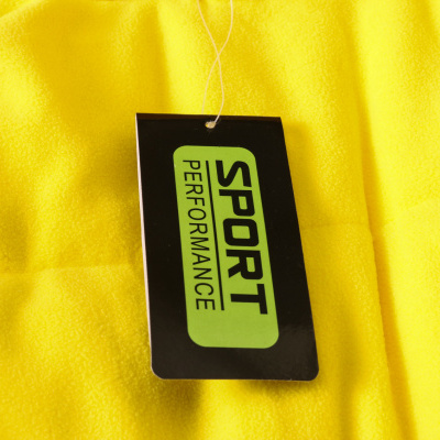 Etiqueta preta com texto SPORT PERFORMANCE em tecido amarelo felpudo.