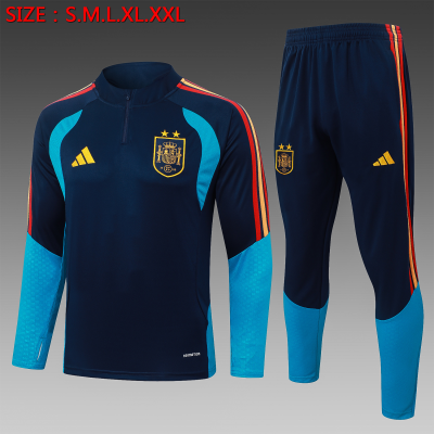 Conjunto de treino desportivo azul escuro com detalhes azul claro e laranja, brasão da Espanha amarelo e texto de tamanhos em vermelho no fundo.