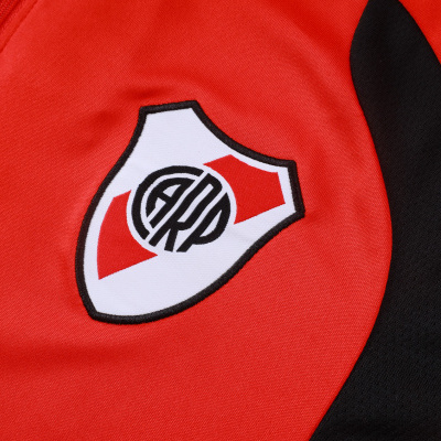 Camisola desportiva vermelha com emblema branco e vermelho e detalhe preto