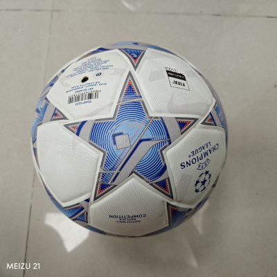 Bola de futebol branca com padrão azul e cinza e texto UEFA CHAMPIONS LEAGUE