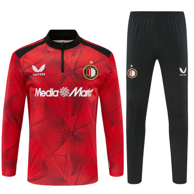 Conjunto desportivo vermelho e preto com logos Castore, Media Markt e Feyenoord Rotterdam.