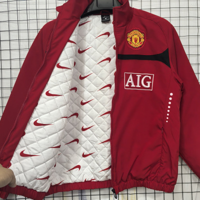 Casaco vermelho Manchester United com interior branco acolchoado e logos Nike.