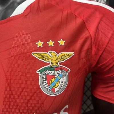 Camisola de futebol vermelha do SL Benfica com emblema e estrelas.