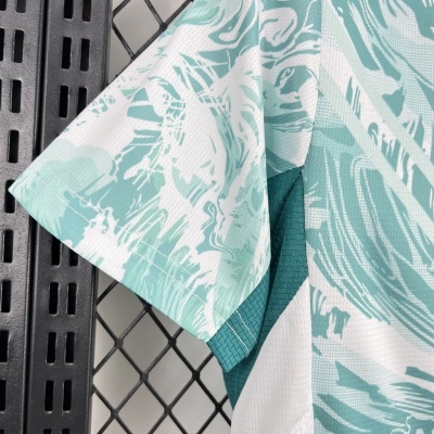 Pormenor de camisa em tecido técnico branco com estampado abstrato verde água e detalhe em malha verde água