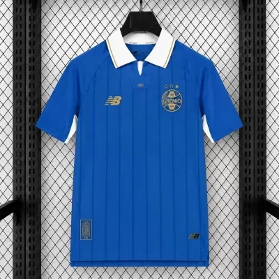Camisola de futebol azul com gola branca e emblemas dourados do Grêmio e New Balance