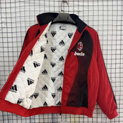Casaco desportivo vermelho e preto com interior branco acolchoado com logótipo Adidas e emblema AC Milan 1899 na frente.