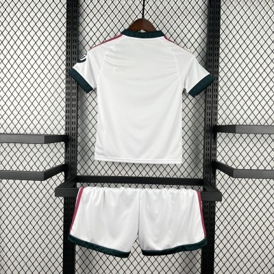 Conjunto de desporto branco com detalhes em verde escuro e rosa pendurado numa estrutura metálica.