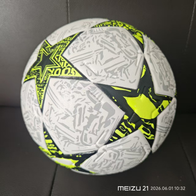 Bola de futebol branca com padrões cinzentos e estrelas verdes fluorescentes
