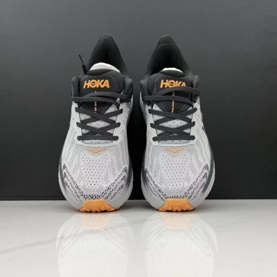Sapatos desportivos HOKA cinza claro com detalhes em laranja e cadarços pretos