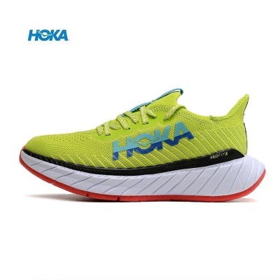 Tênis desportivo amarelo com sola branca e vermelha e logótipo HOKA azul