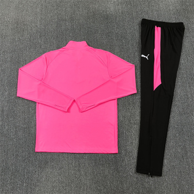 Conjunto desportivo com camisola rosa e calças pretas com detalhes rosa e logótipo Puma