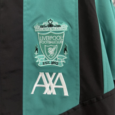 Pano de tecido preta e verde com bordado do emblema do Liverpool Football Club e texto visível