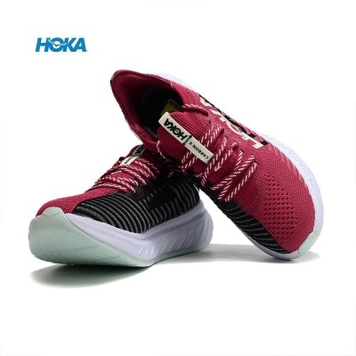 Par de sapatilhas desportivas HOKA cor-de-rosa e preta sobre fundo branco