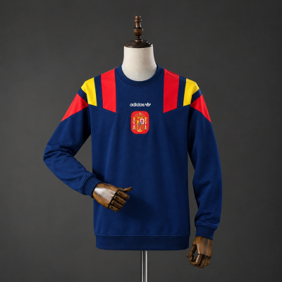 Sweatshirt azul escuro Adidas com detalhes vermelhos e amarelos nos ombros e emblema central