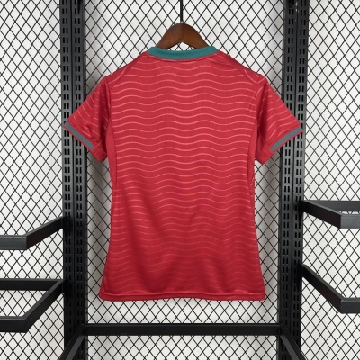 T-shirt vermelha com padrão ondulado pendurada numa rede metálica