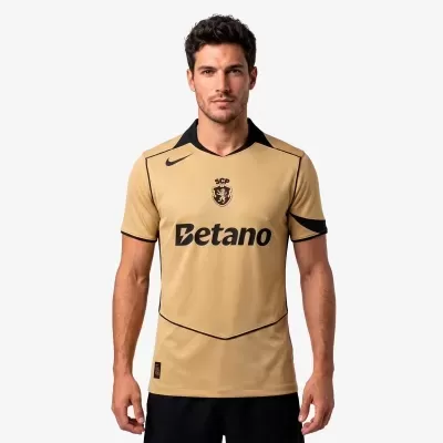 Camisola de futebol dourada com logótipos Nike, SCP e Betano, gola preta
