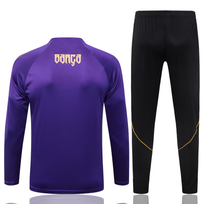 Conjunto de roupa desportiva com camisola roxa e calças pretas.