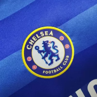 Emblema bordado do Chelsea Football Club em tecido azul às riscas diagonais.
